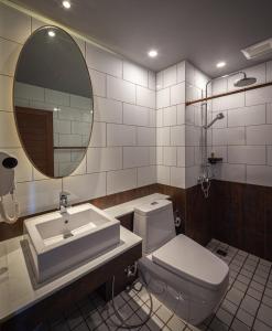 洛坤府Navakitel Design Hotel的一间带水槽、卫生间和镜子的浴室