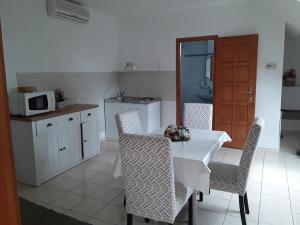 陶波尔曹Családi apartman的厨房配有桌椅和微波炉。