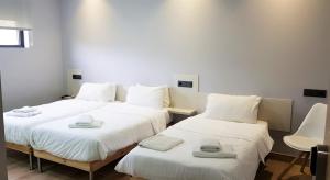 欧德鲁佐LO旅馆的客房内的两张床,配有白色的床单和毛巾