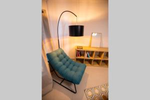 里摩日La veilleuse - Appartement au cœur du centre ville的客厅配有蓝色椅子和书桌