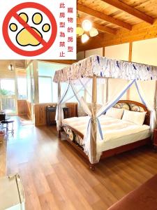 埔里月牙庄休闲度假山庄的一间卧室配有一张带天蓬的床