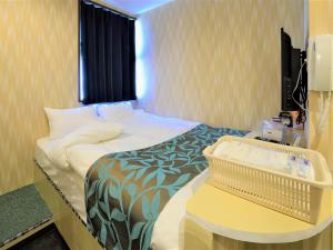 船桥市西船橋駅前 HOTEL的小型酒店客房配有一张床和一张桌子