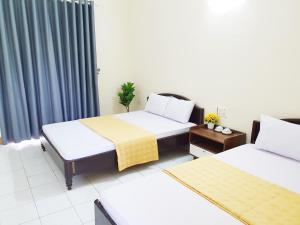 格卢市社Khách Sạn Tuấn Thảo Cửa Lò的酒店客房设有两张床和窗户。