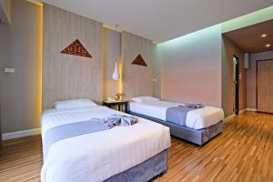 清迈Green Lake Resort - SHA Extra Plus Certified的铺有木地板的客房内的两张床