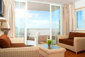 波多黎各马拉开波公寓式酒店的客厅配有椅子、沙发和桌子