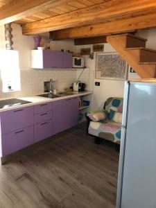 IssogneChez Sylvie Vda-Issogne-001的厨房配有紫色橱柜和沙发