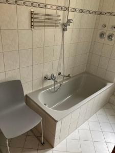 德累斯顿Ferienwohnung Tapetenwechsel -Balkon-的带浴缸的浴室和椅子