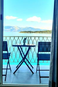 科孚镇Vidos Seaview Suite的阳台配有桌椅,享有水景