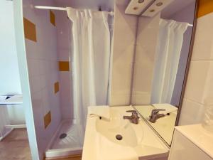 勒卡特HOTEL RESTAURANT LA COTE REVEE的浴室配有盥洗盆和带镜子的淋浴