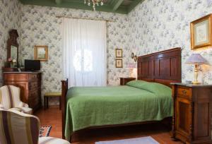 维泰博法里内拉别墅旅馆的一间卧室设有一张绿色的床和一个窗户。