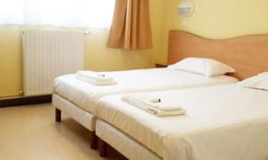 斯特拉海滩Stella Maris的配有白色床单的酒店客房内的两张床