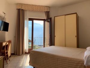 利莫内-苏尔加达Villa Belvedere Hotel的一间卧室设有一张床和一个滑动玻璃门
