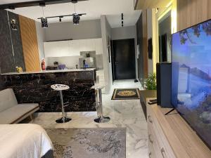 阿卜杜勒国王经济城Maqeela Luxury Studio的厨房以及带大屏幕电视的客厅。