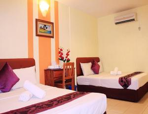 Kampong Batu LapanSun Inns Tambun的酒店客房设有两张床和一张桌子。