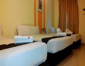 Kampong Batu LapanSun Inns Tambun的一间酒店客房内设有三张床的房间