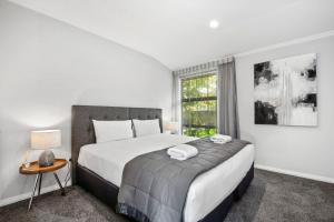 陶波River View Retreat - Taupo的一间卧室设有一张大床和一个窗户。