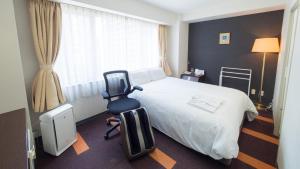 大阪新大阪酒店的配有一张床和一把椅子的酒店客房
