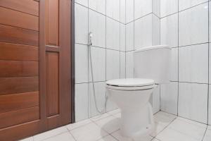 巴厘巴板RedDoorz at Vall Guest House Balikpapan的浴室配有白色卫生间和淋浴。