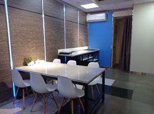 伊热夫斯克奥斯汀洛夫酒店的一间会议室,配有桌子和白色椅子