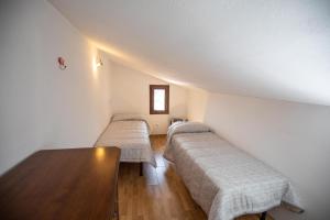 Isola del GiglioCasaMatta2的一间设有两张床和一张桌子的房间