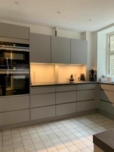 哥本哈根ApartmentInCopenhagen Apartment 720的厨房配有白色橱柜和白色瓷砖地板。