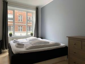 哥本哈根ApartmentInCopenhagen Apartment 720的卧室内的一张床位,带窗户