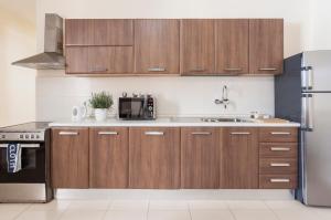 埃尔哥茨拉Blubay Apartments by ST Hotels的厨房配有木制橱柜和冰箱。