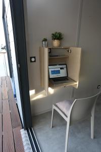 格吕桑Les Ilots de Gruissan的一张桌子,一张笔记本电脑和一把椅子放在房间里