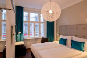 维也纳维也纳国家歌剧院一号汽车旅馆的一间卧室配有一张大床和一个吊灯。