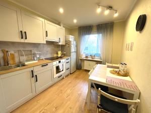 里加Cozy Home Apartment Lielvardes, free parking, self check-in的厨房配有白色橱柜和桌子