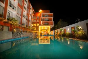 迪卡Abhyagama Hotel的一座游泳池,在晚上在建筑物前