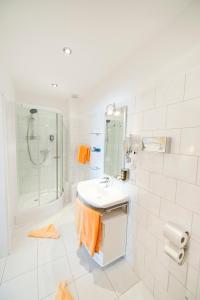巴特瑙海姆斯浦特尔酒店的白色的浴室设有水槽和淋浴。