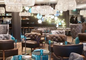 伦敦伦敦塔山一号汽车旅馆的餐厅设有桌椅和吊灯。