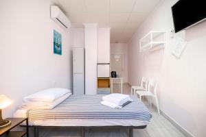 托雷维耶哈Hostal 7A的小房间设有一张床、一张桌子和椅子