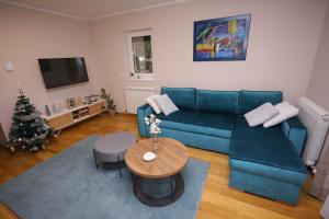 兹拉蒂博尔Mipet apartmani的客厅配有蓝色的沙发和圣诞树