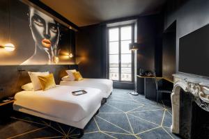 勒芒Leprince Hotel Spa; Best Western Premier Collection的一间酒店客房,设有两张床和电视