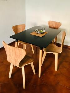 胡宁AMANECER Rent Apart - Tú Hogar! Amplio y Luminoso con Desayuno的一张带椅子的黑色餐桌和一碗水果