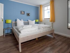 宾茨Villa Binz - Apt. 05的一间卧室配有一张带白色床单的床和一扇窗户。