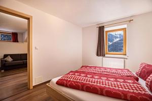 卡迪皮特拉Golserhof Kristall的一间卧室设有红色的床和窗户。