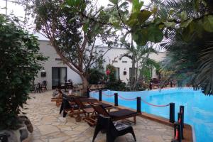 杜柏热带酒店的一个带游泳池、椅子和树木的度假酒店