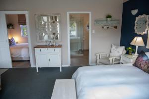 BergvlietCape Cottages的一间带白色床的卧室和一间带浴室的卧室