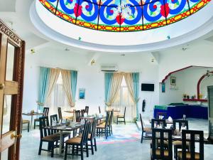 Al ‘Aqar雅巴尔艾赫代尔酒店的一间带桌椅和天花板的用餐室