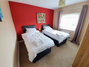 贝弗利Beverley Central Townhouse Free Parking Sleeps 8的红色墙壁的客房内的两张床