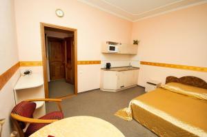 尼古拉耶夫Viva Hotel的一间卧室配有一张床铺和一张桌子,还设有一间厨房