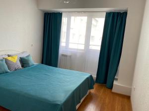 安加尔斯克Apartments 29 micro-district的一间卧室设有蓝色的床和窗户。