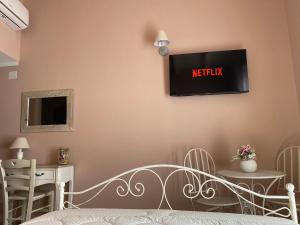 圣维托La Soffitta di EmmaSofia的卧室配有一张床,墙上配有电视。