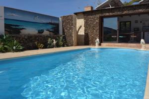 维拉韦德Villa Maravilla piscina climatizada的房屋前的游泳池