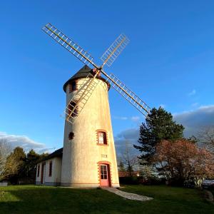 Saint-Georges-du-Puy-de-la-GardeLE MOULIN DES GARDES的坐在草地顶上的风车