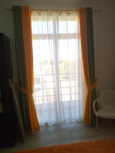 蒙巴萨Pride Studio Mtwapa的窗户,有橙色和绿色的窗帘