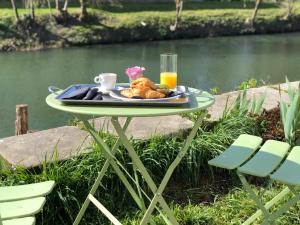 DamvixLa Belle Epoque - Chambres d'hôtes & SPA的河边一张桌子,上面放着一盘食物